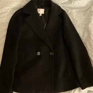 Svart kappa, i ganska bra skick - Jätte bra i skick, sitter jätte fint på säljer pågrund av att jag använder knappt den 