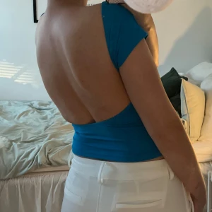 Topp med öppen rygg - Superfin topp med öppen rygg i en så härlig färg. Den har en bra längd som passar bra till lågmidjade byxor. Toppen är helt ny och endast provad. 🩵