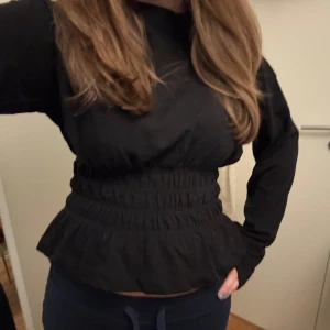 Svart topp - Svart långärmad topp från hm. Så fin detalj i midjan. 