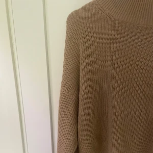Beige stickad tröja från NA-KD - Säljer en supermysig beige stickad tröja från NA-KD i storlek S. Perfekt för höst och vinter med sin varma och sköna känsla. Tröjan har en hög krage och långa ärmar, vilket gör den idealisk för kyliga dagar. Den är i nyskick 