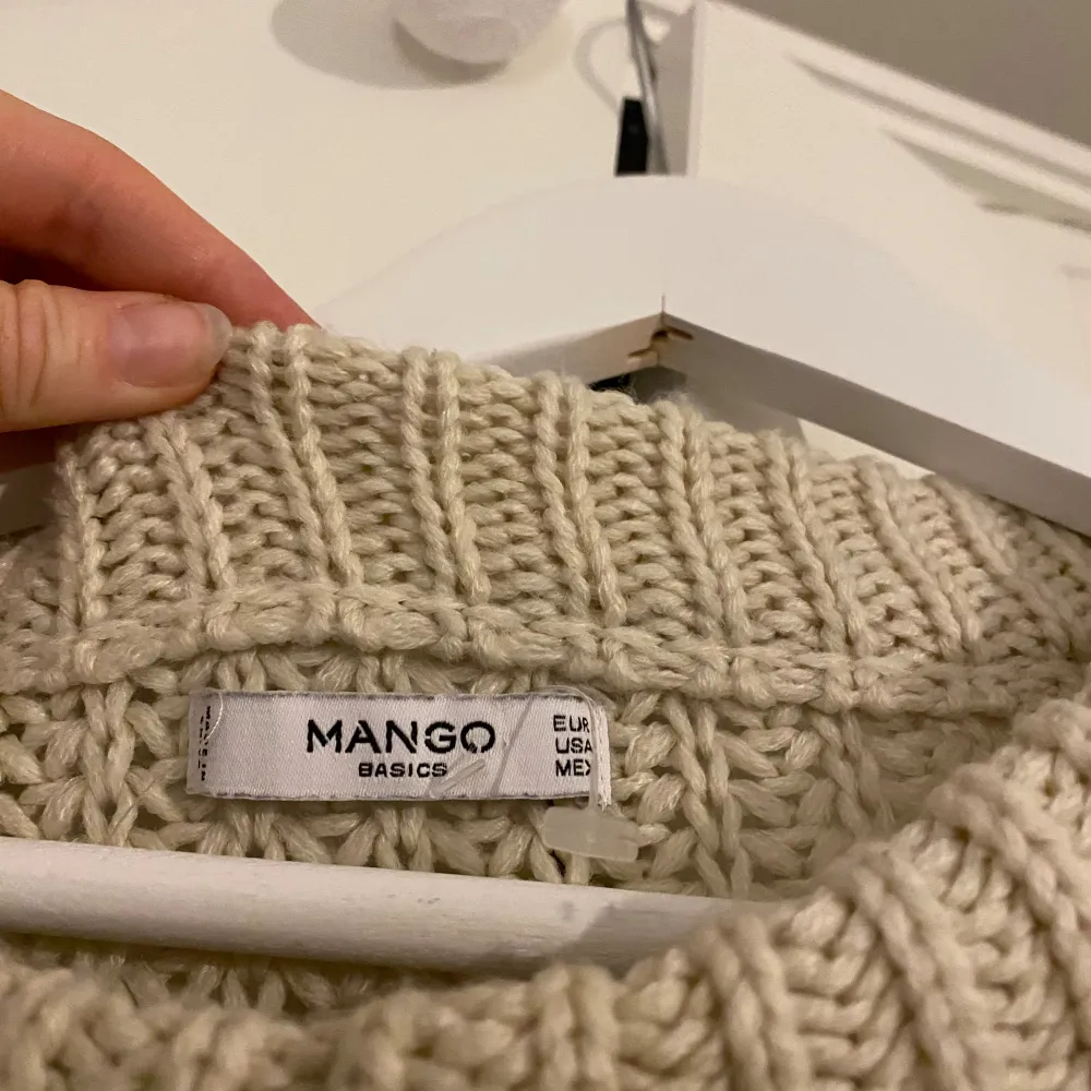 Säljer en supermysig beige stickad tröja från Mango Basics. Perfekt för kyliga dagar med sin tjocka och varma design. Tröjan har en rund hals och långa ärmar, vilket gör den idealisk för både höst och vinter. Den är i nyskick och redo att bli en del av din garderob!. Tröjor & Koftor.