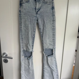 Bootcut jeans stl xs - Ljusblåa Bootcut jeans i storlek xs med hål på knäna från bikbok. I bra skick.