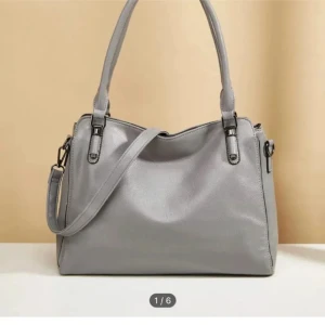 Väsk  - Rymlig grå handväska som har många fack! Tillkommer även ett långt band 