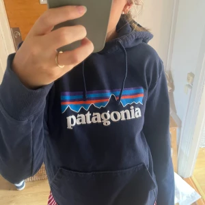 Patagonia hoodie - Mörkblå patagonia hoodie. Mysig tröja och perfekt till hösten. Väldigt sparsamt använd och kostade 1000kr ny. Säljes pga kommer inte till användning. Storlek small och sitter snyggt på mig som brukar ha det.🥰🤗