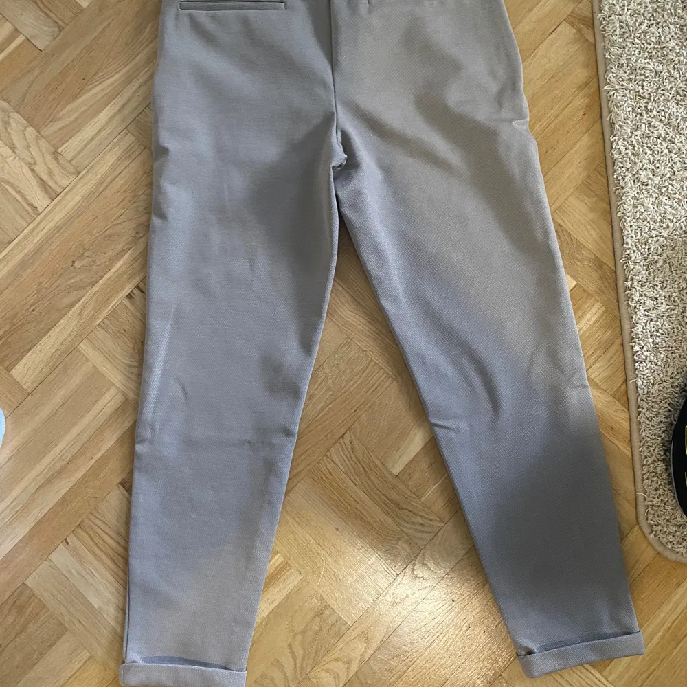 Säljer ett par bekväma beige byxor från Zara. De har en elastisk midja med snörning för perfekt passform. Materialet är mjukt och skönt. Byxorna har en stilren design utan onödiga detaljer.. Jeans & Byxor.