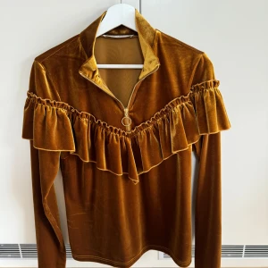 Topp Gestuz - Sammetstopp från Gestuz med volang och dragkedja i halsen i storlek S. Blekt fläck i nacken.