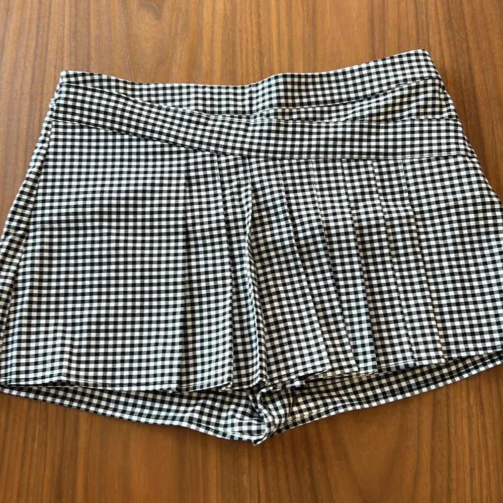 Säljer ett par snygga svartvitrutiga shorts från Zara. De är högmidjade och har en klassisk rutigt mönster som ger en stilren look. Perfekta för både vardag och fest! 🖤. Shorts.