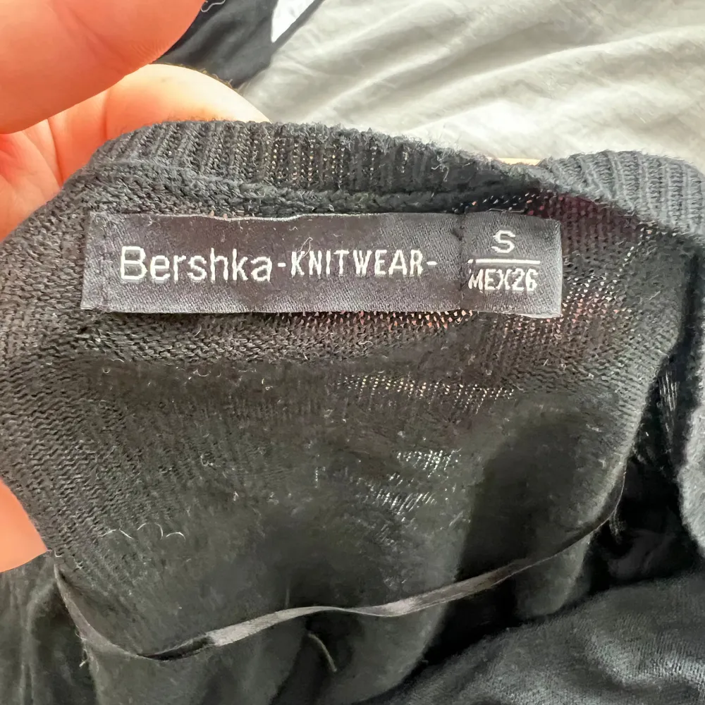 Säljer en svart lång kofta från Bershka. Den är stickad och har en v-ringad design med knappar framtill. Perfekt för höst och vinter, och den har praktiska fickor. Koftan är i nyskick och redo för en ny ägare!. Tröjor & Koftor.