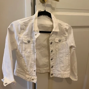 Vit jeans jacka - En vit jeans jacka. Inga defekter. Jackan är i en liten storlek men man kan använda den även om man har en större storlek, den blir då ”cropped” och tre kvarts armar