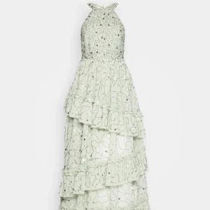 Grön balklänning - Säljer denna fantastiska slutsålda pistagegröna långklänning från Maya Deluxe. Den har glittriga detaljer, paljetter och volanger. Klänningen har en öppen rygg och knyts med en rosett av satin i nacken. Perfekt för bal, bröllop eller andra tillställningar! Endast använd en gång i samband med bal så den är helt felfri och så gott som i nyskick. För fler bilder skicka ett meddelande🫶🏼Frakt tillkommer.                                                   Nypris 2345:-