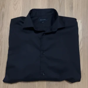 Svart skjorta från Riley - Säljer en stilren svart skjorta från Riley. Riktigt snygg och stilig, använd 1 gång 10/10 kvalite! Nypris 700kr. Pris 199kr.