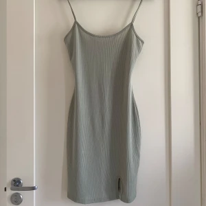 Mintgrön klänning - Kortklänning i ribbat tyg med liten slits. Stretchig och mjukt material.