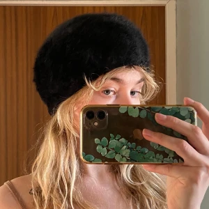 Pälsmössa - Svart fluffig mössa/basker från Kangol. Står ingen storlek, mätte omkretsen till 52 cm men jag har 58 cm huvud och kan ha den, så passar nog någon där emellan dock inte större. Jättefint skick! Dessa går ofta för runt tusenlappen!!