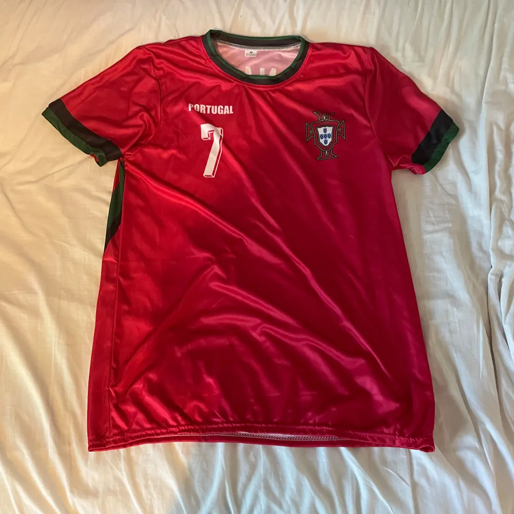 Säljer en riktigt snygg fotbolls tröja från Portugal med tryck cr7 på ryggen. Helt ny. Skick 10/10. Strl M.. T-shirts.