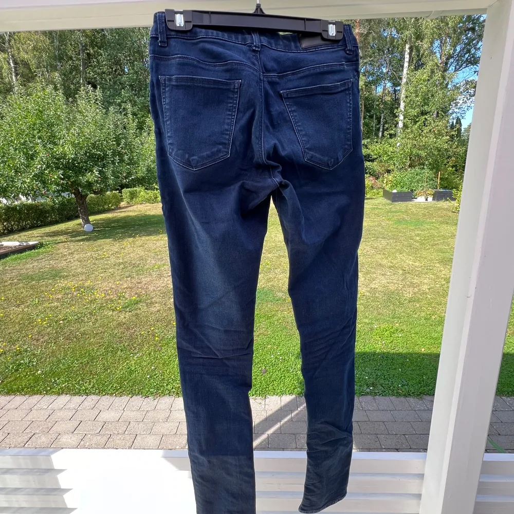 Ett par mörkblå jeans från Bikbok. Storlek M. Använda ca 10 gånger 💙  Innerbenslängd: 81 cm Midja: 76 cm. Jeans & Byxor.