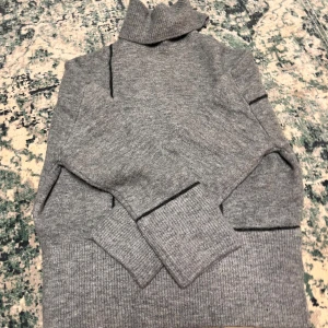Grå stickad polotröja från Zara - Säljer en supermysig grå stickad polotröja från Zara. Perfekt för höst och vinter när du vill hålla dig varm och stilren. Tröjan är i nyskick, aldrig använd. Nypris 600