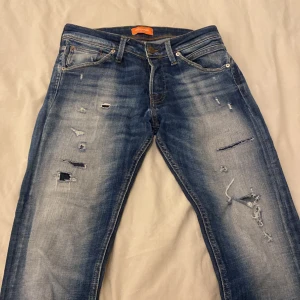 Blå Jack & Jones jeans - Säljer dessa feta Jack & Jones jeans (Slim/Glenn) storlek W29 L30. Skriv vid några funderingar. Hål i skrevet men går enkelt att laga👍