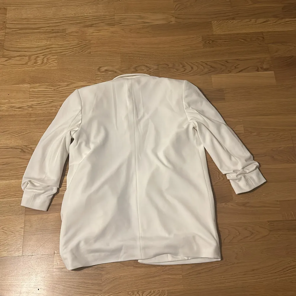 Snygg vit kavaj från Calliope i storlek M. Den har en stilren design med långa ärmar och en öppen framsida. Perfekt för att ge en elegant touch till din outfit.. Takit.