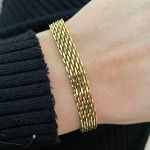 18k guldarmband med kedjedesign - Elegant 18k guldpläterad armband med en fin kedjedesign. Helt oanvänd. Perfekt för att lägga till en touch av stil till din outfit. Armbandet har en justerbar kedja för att passa olika storlekar. Minsta storlek är 16 cm och som störst 21,5 cm. Du kan duscha, sola och bada med den. Nypris 499kr, fick i present. Köparen står för frakten. 