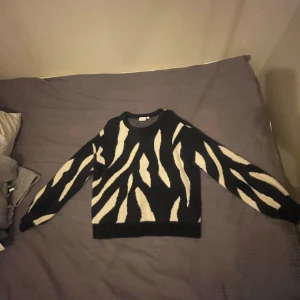 Svart och vit mönstrad tröja från Vila - Snygg svart tröja med vitt zebramönster från Vila. Tröjan har en normal passform och långa ärmar, perfekt för att sticka ut i mängden. Den är tillverkad i ett mjukt material som känns skönt mot huden. Pris kan diskuteras och skriv för fler bilder om det behövs