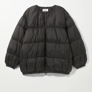 Svart pufferjacka från Weekday - Snygg svart pufferjacka model Kai från Weekday. Jackan har en oversized passform och långa ärmar, perfekt för kyliga dagar. Den quiltade designen ger en modern look. 
