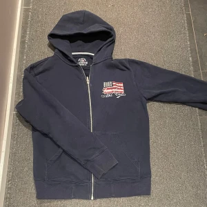 Mörkblå hoodie från Lexington - Säljer en snygg mörkblå hoodie från Lexington med dragkedja och en cool amerikansk flagga på bröstet. Hör av er om ni undrar något 🙌