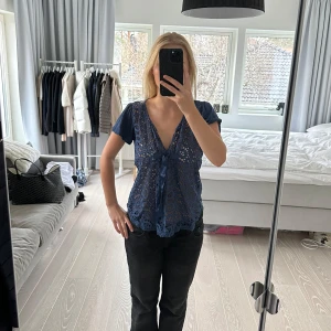 Blå spetsblus från Odd Molly - Säljer en vacker blå spetsblus från Odd Molly. Blusen har korta ärmar och en knytning framtill. Perfekt för en stilren look med en touch av elegans. Storlek 2 vilket motsvarar S/M