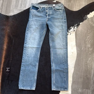 Blå jeans från Zara - Snygga blå jeans från Zara med klassisk femficksdesign och knappgylf. De har en rak passform och är perfekta för en avslappnad stil. Jeansen har en lätt tvättad look som ger dem en cool vintagekänsla.