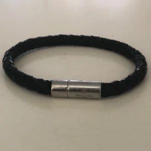 Svart flätat armband från Skultuna - Elegant svart flätat armband från Skultuna med ett stilrent silverfärgat lås. Perfekt accessoar för en sofistikerad look. Skultuna-logotypen är ingraverad på låset. Nypris 800kr mitt pris 159kr🤩