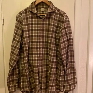 Brun och vit rutig skjorta från Stenströms - Snygg brun och vit rutig skjorta från Stenströms i storlek XL. Skjortan har långa ärmar och knappar framtill. Perfekt för en stilren look med en klassisk touch.
