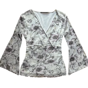 Blommig vintage omlottopp med vida ärmar -  vacker blommig omlottopp med vida ärmar. Lappen bortklippt. Men passar en XS/S. Mesh material. 