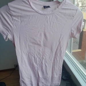 Ljusrosa soft touch t-shirt från Gina Tricot - Säljer en ljusrosa t-shirt från Gina Tricot i storlek XS. Den är kortärmad och tillverkad i mjukt bomullsmaterial. Perfekt för en avslappnad stil.