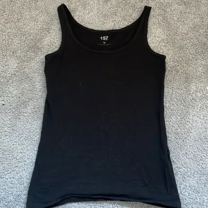 Svart linnetopp från 157 - Säljer ett svart linne i storlek xs från Lager 157.Säjer pågrund av jag inte har använt de.Har inga skador och fin passform🩷