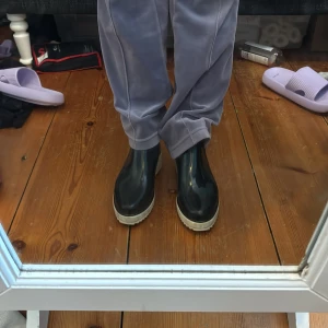 Svarta boots med vit sula - Snygga svarta boots med en kontrasterande vit sula. Perfekta för en stilren look och passar bra till både jeans och byxor. De har en enkel design utan snörning eller dragkedja.