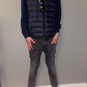 Marin blå uni qlo väst  - Snygg marinblå dunväst med dragkedja, perfekt för våren. Västen har en quiltad design som ger extra värme och stil. Passar människor som är mellan 165-175