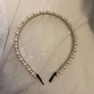 Diadem med pärlor - Elegant diadem dekorerat med vita pärlor. Perfekt för att ge en stilfull touch till din look. Diademet har en klassisk design som passar till många olika tillfällen.