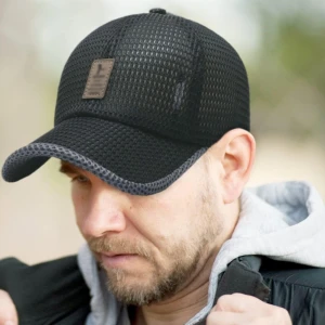 Svart meshkeps med läderdetalj - Snygg svart keps i meshmaterial med en cool läderdetalj framtill. Perfekt för en avslappnad stil och bra ventilation. Justerbar passform för optimal komfort. Perfekt för en varm sommardag när man spelar golf.