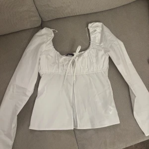 Vit blus med knytband - Helt ny vit blus med knytband som tyvärr inte kommit till användning💘💘