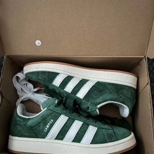 Adidas Campus 00s - Använt dom ett fåtal gånger det enda dåliga med skorna är som man ser på sista bilden lite smuts men går säkert att tvätta bort. Priset kan diskuteras vid snabb affär. Vita och gröna lite större snören följer med och även gröna vanliga snören.