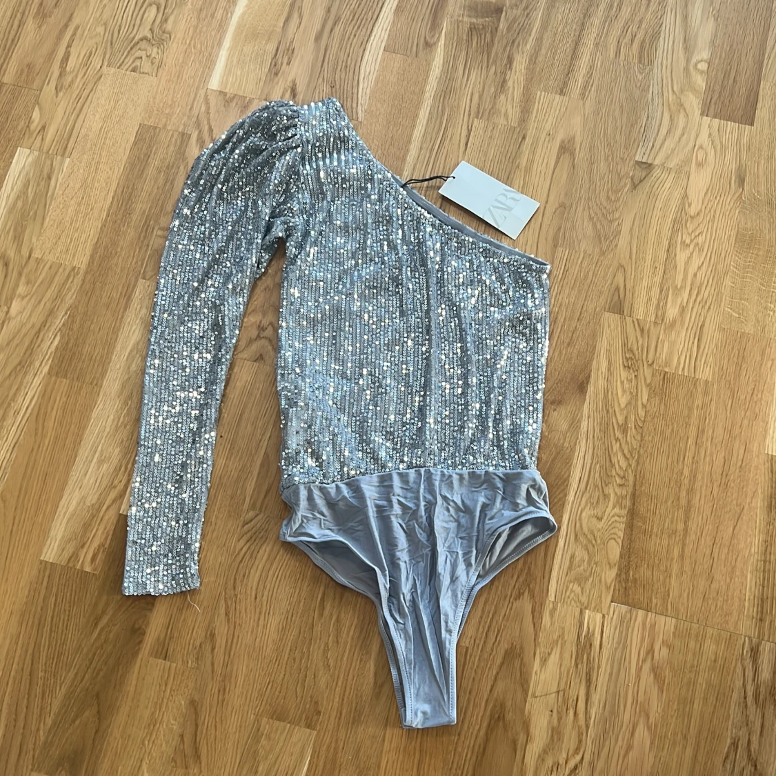 Glittrig oneshoulder body i silver - 1