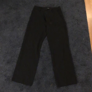 Svarta kostymbyxor från Lindex - Snygga svarta kostymbyxor från Lindex i storlek EUR 40. Byxorna har en klassisk design med dragkedja och knapp framtill. Perfekta för en stilren look. Supersköna och väldigt snygga!!😍😍