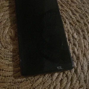 Svart smartphone - Säljer en svart smartphone med en stor skärm. Perfekt för dig som behöver en pålitlig telefon för vardagligt bruk. Skärmen ser ut att ha en liten skada i hörnet.
