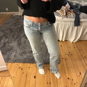 Blå jeans från Zara - Säljer ett par klassiska blå jeans från Zara med låg midja. De har en straight passform och är tillverkade i denim. Perfekta för en avslappnad stil.