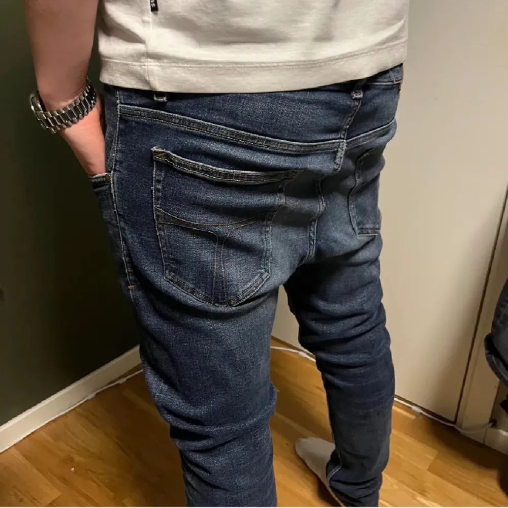 Snygga mörkblå tiger of sweden jeans med en slim passform. Byxorna har klassisk femficksdesign och stängs med dragkedja och knapp. Perfekta för en stilren look. Storlek w31 L32. Kontakta mig vid frågor. Farkut & Housut.