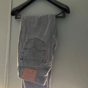 Grå Levis 501 jeans - Snygga grå Levis 501 jeans i klassisk design. De har en rak passform och är tillverkade i slitstarkt denim. Perfekta för en stilren look med den ikoniska Levis-lappen på baksidan. Hör av dig vid minsta fundering! Pris ej hugget i sten, väljer du att köpa fler artiklar från min sida kan jag ge ett ett billiga pris👍 finns även på Vinted!. Fraktar inom 48 h W30 l30