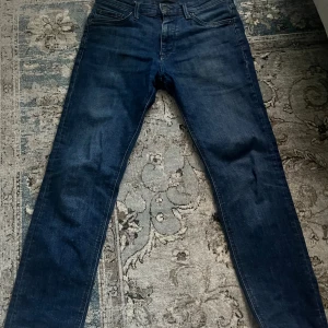Blå jeansbyxor Regular/Clark - Snygga blå jeansbyxor i modellen Regular/Clark ifrån Jack and Jones. Storlek 28/30. Ett par väldigt sköna jeans och perfekt om man har häng (enligt mig). Använda ett par gånger. Nackdelen är två fläckar vilket kan leda till att priset kan sänkas. Som sagt är priset inte hugget i sten. Kontakta mig angående frågor. 