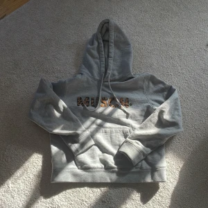 Grå hoodie med leoparddetaljer från Musch - Säljer en grå hoodie från Musch med leopardmönstrad text på bröstet. Mycket bra sick 