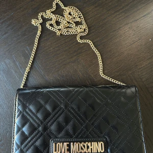 Love moschino - Mått Bredd 22cm Höjd 14cm  Svart moschino väska som är i väldigt gott skick och använt väldigt varsamt. Det finns inga skador på väskan! 