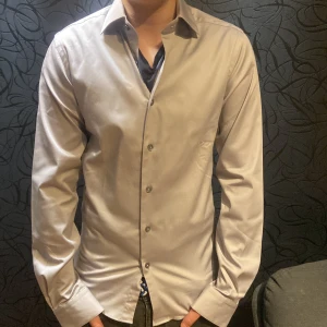 Grå skjorta från dressmann - Säljer nu min gråa dressmann skjorta för att jag växt ut den. Storlek 35 36/Xs slim fit. Skick som ny 10/10. Perfekt till våren/sommaren. Priset är inte hugget i sten 