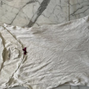 Vit ribbad linnetopp ifrån oddmolly - Jätte gulligt linne ifrån odmolly. Linnet säljs inte längre. Den har detaljer längst kanterna och sitter lite pösigare i passformen men går in i midjan vilket skapar en fin form. Säljer då den inte kommer till någon andvändning. Framtill har den en minimalistisk smink fläck som inte är något man tänker på alls. Skriv gjärna vid frågor.🩷